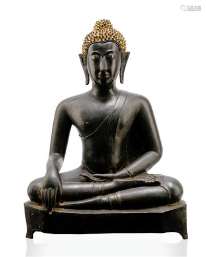 A BRONZE FIGURE OF BUDDHA SHAKYAMUNI, Thailand, Ayutthaya period, 17th Ct., seated in virasana on a pedestal with his right hand in bhumisparshamudra while the left is resting on his lap, wearing samghati and uttarasangha, his face displaying a serene expression with downcast eyes below arched eyebrows that run into his nose-bridge, elongated earlobes, curled hair and ushnisha, traces of gilt- and black-lacquer - Property from a German private collection, acquired in the Netherlands between 1950 and 1970 - Minor wear, partly small damages due to age, flame lost