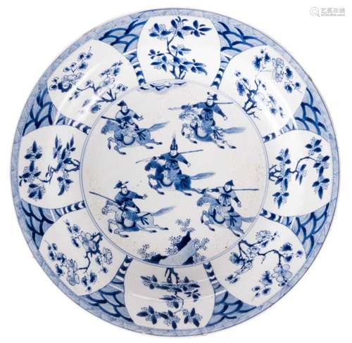 A Chinese blue and white Kangxi dish, depicting warriors on horses, marked Chenghua, Diameter 34,5 cm (chips on the rim)