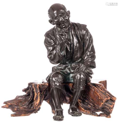 A Japanese bronze statue depicting an old man smoking a pipe, on a wooden carved base, marked, H 41 - W 40 - D 37 cm (small damage)