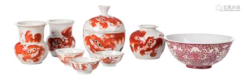 A lot of Chinese iron red porcelain, decorated with Fu lions, some items marked, H 3 - 13 cm; added a Chinese rose ground polychrome floral decorated bowl, with bats and auspicious symbols, with a Qianlong mark, H 6,5 - D 16 cm