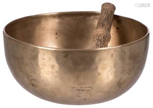 A Tibetan bronze singing bowl with a matching wooden bat, H 12 - Diameter 26 cm