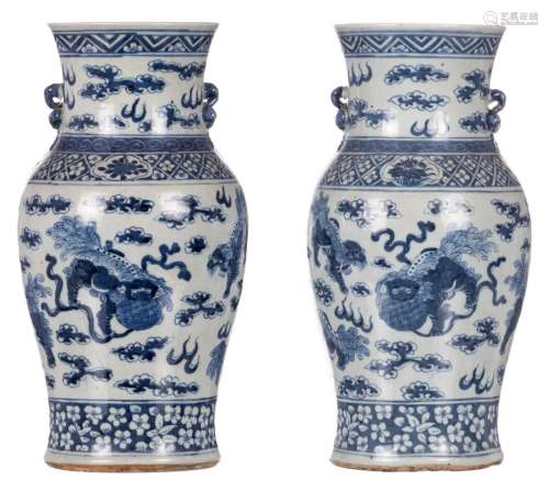 A pair of Chinese blue and white vases, decorated with Fu lions, 19thC, H 35,5 cm (crack)