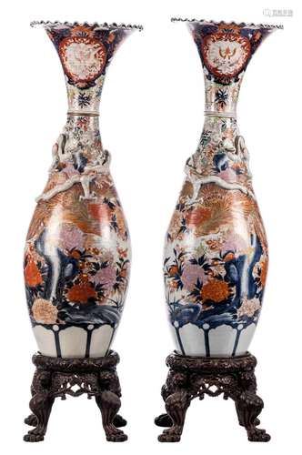 A pair of Japanese Arita vases, polychrome decorated, Meiji period, with matching sculptured wooden bases, H 147,5 (without base) - H 181,5 cm (with base) (restorations)