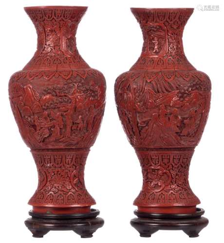 A pair of Chinese red cinnabar lacquer baluster shaped vases, overall decorated with figures in a landscape, on matching wooden stands, 19thC, H 53,3 cm (with base) H 47,5 cm (without base)