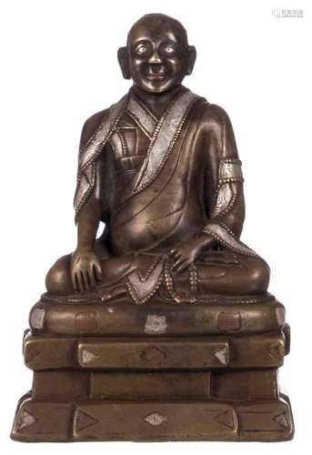 A Chinese bronze figure of a seated lama, H 10,5 - W 10,5 - D 7 cm