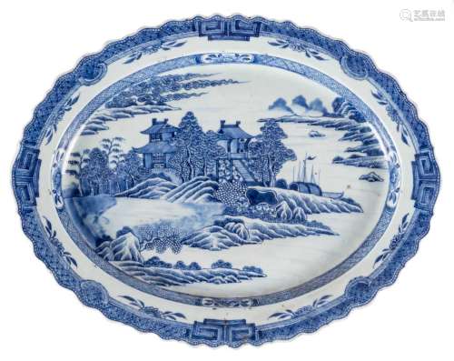 A Chinese oval blue and white dish depicting a river landscape, 18thC, 41 x 53 cm