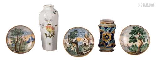 An 18thC Italian polychrome decorated albarello, H 14,5 cm; added three 18thC polychrome decorated majolica dishes, Diameter 13,5 - 14 cm; extra added an 18thC tin glazed earthenware vase, polychrome decorated in the manner of Meissen, H 21,5 cm (damage)