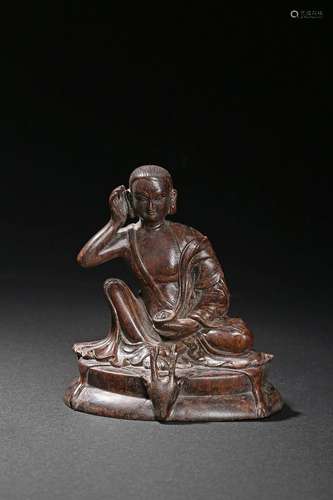 An agarwood carving of seated Milarepa