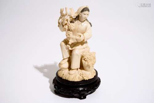 A Chinese carved ivory figure of a girl with grapes, 2nd quarter 20th C.
