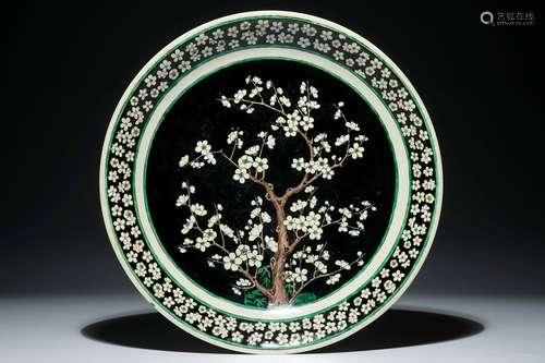 A Chinese famille noire on biscuit prunus tree charger, Kangxi