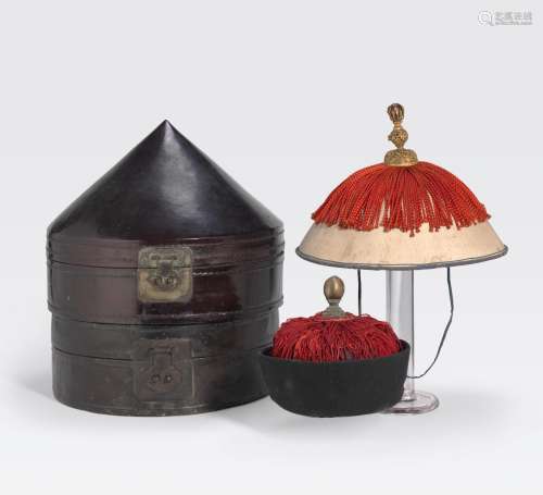 TWO MANCHU COURT HATS AND TWO LACQUEREDLEATHER HAT STORAGE BOXES