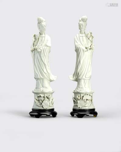 A PAIR OF GLAZED WHITE PORCELAIN BEAUTIES HOLDINGLOTUS BRANCHES