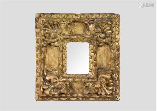 Très petit miroir avec large cadre en bois mouluré doré, les écoinçons sculptés de coquilles.