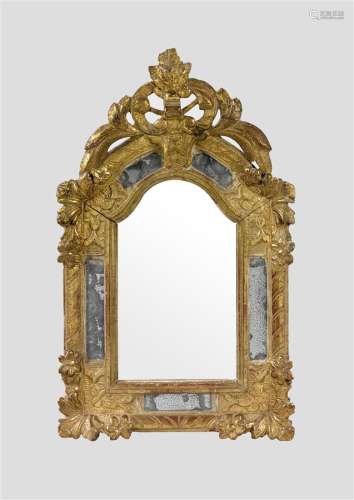Petit miroir mouluré à parecloses en bois doré, le fronton ajouré de feuillages, les écoinçons de fleurs sur fond amati.