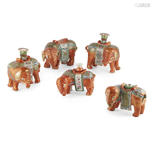 FIVE CANTON FAMILLE ROSE IRON-RED GROUND CANDLE HOLDERS IN THE FORM OF ELEPHANTS