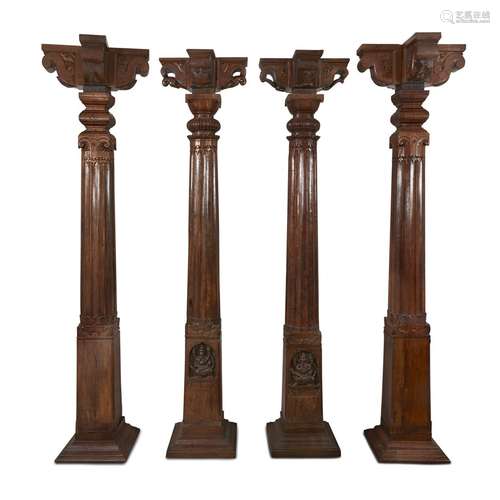 A set of four associated Indian carved teak columns, capitals and bases,