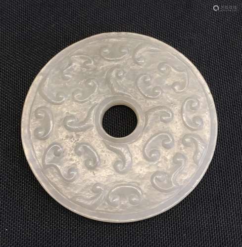 A Chinese carved greyish-white jade archaistic bi disc,