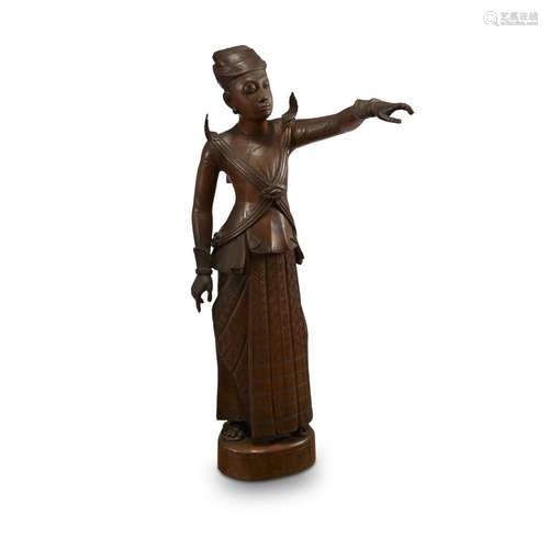 A Burmese carved wood figure of a standing man, pointing in the distance,