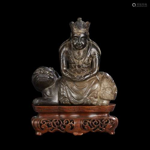 A Chinese brownish-grey jade figure of Guanyin seated on a lion, possibly kangxi period, 17th/18th century