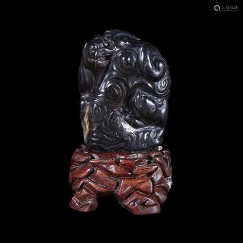 Carved dark brown and black jade finial, possibly kangxi period, with later carved wood stand