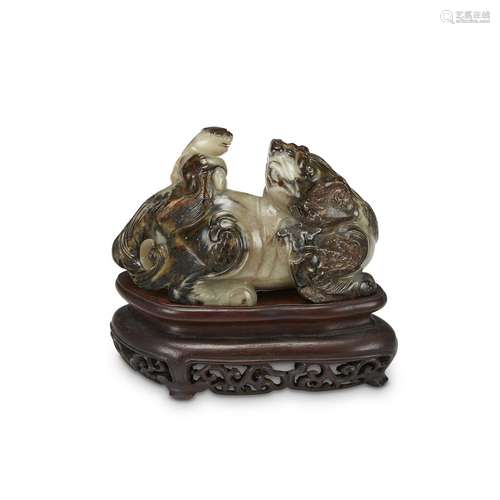 A Chinese carved brown and grey-white jade Dashi Xiaoshi lion group, in Ming style,