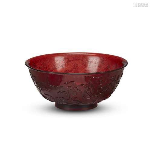 A Chinese ruby glass bowl, carved with birds among flowering branches, four-character qianlong mark and probably of the period