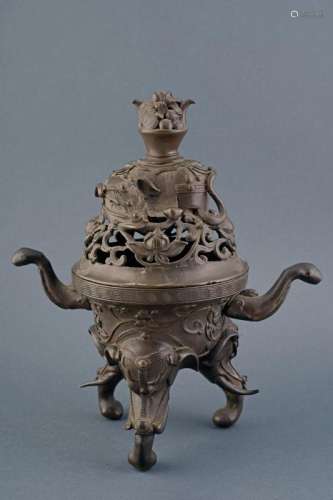A bronze incense burner with dark patina