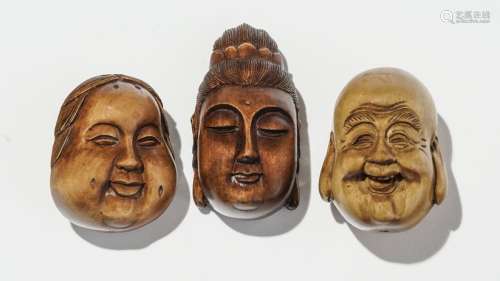 Ensemble de trois netsukés, JaponBois de buis représentant des têtes de bouddha, deux signés, L 5 cm et L 6 cm