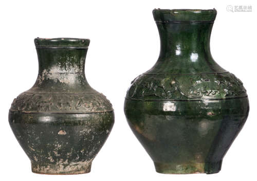 Two green glazed earthenware wine jars of the Han type, with relief decorated friezes, H 29,5 - 36,5 cm