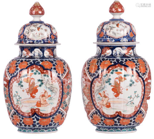 A pair of Japanese Imari decorated vases and covers, the roundels with animated scenes, birds and flower branches, 19thC, H 52 cm