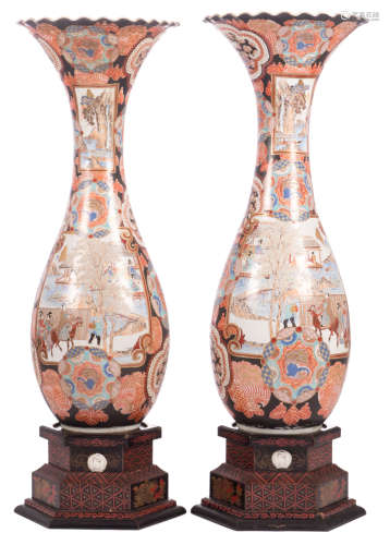 A fine pair of Japanese Meiji period vases, overall polychrome and relief decorated with dragons and phoenixes, the roundels with figures in various landscapes, marked, on a matching polychrome and gilt lacquer wooden stand with on top a porcelain plaque, H 94 - 114 cm