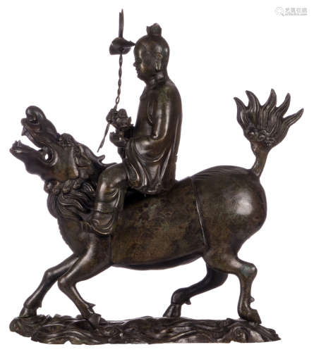 A Chinese patinated and gilt decorated bronze figure, seated on a Fu lion, H 73,5 cm