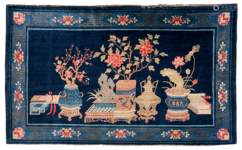 A Chinese rug, decorated with antiquities and flower branches, wool on cotton, 162 x 264 cm