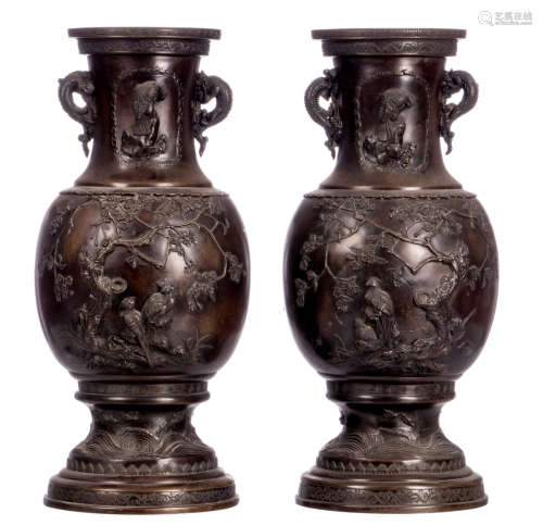 A pair of Japanese patinated bronze ornamental vases, overall relief decorated with an animated scene and birds and flower branches, the handles dragon relief decorated, Meiji period, H 46 cm