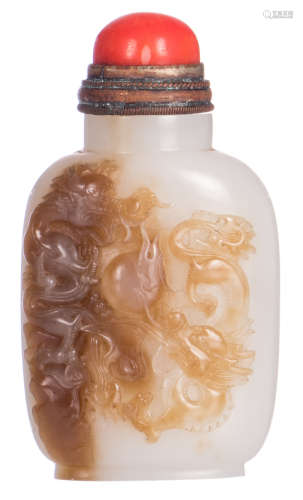 A Chinese light celadon coloured and brown jade snuff bottle, depicting two Chilongs playing with a flaming pearl, the cap of blood coral, H 7,5 cm