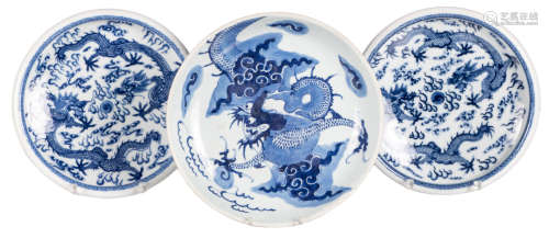 Two Chinese blue and white dishes, decorated with dragons playing with a flaming pearl, H 6,5 - ø 26,5 cm; added a ditto celadon dish, possibly with mark of the owner, H 6 - ø 28,5 cm