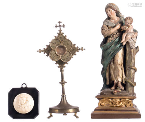 A polychrome painted limewood Holy Mother and Child, presumably German - Black Forest, mid 19thC, H 39 cm; added a Gothic Revival brass monstrance with its relics, 19thC, H 33 cm; extra added an ivory alto relievo depicting a crying Madonna, on a synthetic resin plaque, 1920's, B 10,5 - ø 6,8 cm