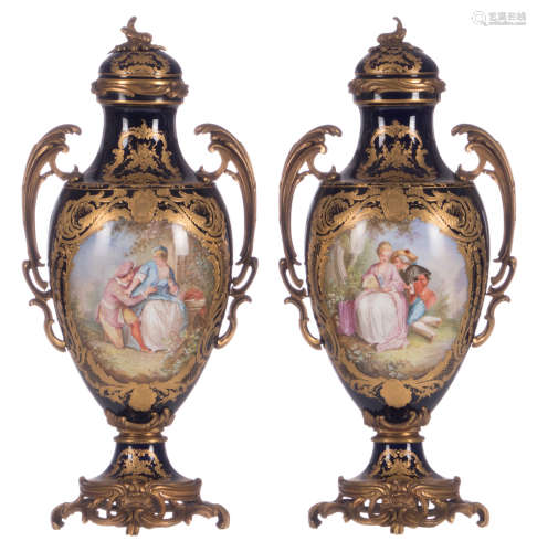 A pair of ornamental vases with gold-layered bleu royal ground, decorated with gallant scenes and park views, signed Poitevin, gilt bronze Rococo style mounts, with a blue overglaze Sèvres mark and date letter E, H 44 cm