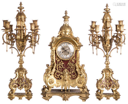 A LXIV style gilt bronze mantle clock and matching candelabras, marked 'Garrard & V. - Ets. d'horlogerie - Paris', the front and sides of the clock and the bases of the candelabras in painted brass tin, H 67,5 (clock) - 73,5 cm (candelabras)