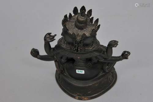 Bronze image of a Buddha. Tibet. 17th century. Seated tantric image with eight arms and three faces. Deep black patina. 7-1/2