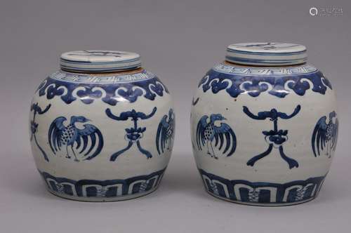 Pair of porcelain covered jars. China. 19th century. Underglaze blue decoration of cranes and bats. Ju-i borders. 9