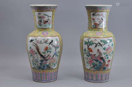 Pair of porcelain vases. China. 19th century. Famille Rose decoration of reserves of birds and flowers on a yellow ground with stylized lotus scrolling. Drilled. 17-1/2