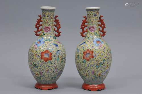 Pair of porcelain vases, China Ch'ien Lung marks. Early 20th century bottle form with coral red handles and stands. Famille rose decoration of floral scrolling on a pale yellow ground. 8-1/2