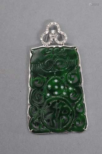 Jadeite pendant, China 20th century. Emerald green color carved an pierced with dragons, a cash coin, and a fu character. 14K white gold mount with diamonds. 1 1/2