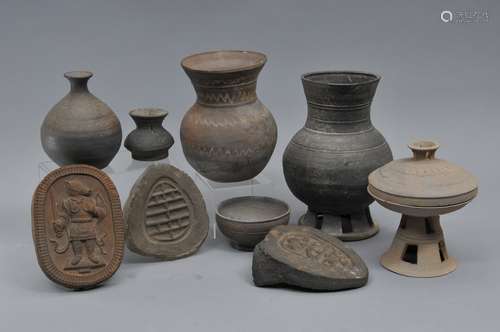 Lot of nine pieces of stoneware. Korea. 6 Silla wares including four vases, a covered offering dish and a cup and three roof tiles, one decorated with protective deity. Largest 10