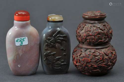 Lot of three snuff bottles. China. 19th/20th century. Double gourd bottle of cinnabar lacquer carved with flowers. (damage to the top). And two agate bottles carved with goldfish. 2-1/2