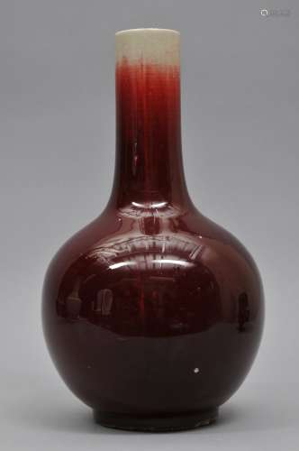 Porcelain vase. China. Late 19th to early 20th century. Bottle shaped. Oxblood glaze running to white at the mouth. 14