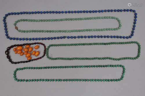 Lot of beads to include: A faceted amber necklace and assorted amber beads. A strand of lapis beads, a strand of malachite beads and two strands of jade beads.