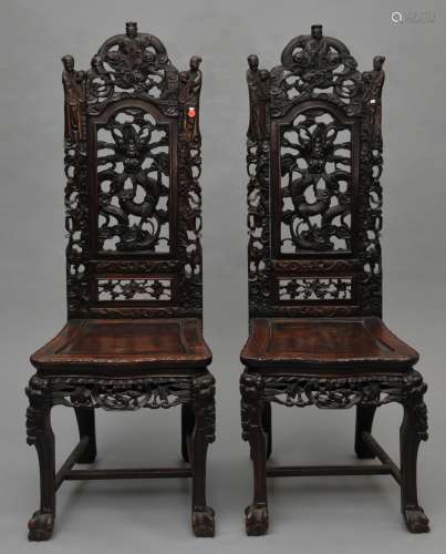 Pair of hardwood chairs. China. 19th century. Tall backs carved with human figures, dragons and floral scrolling. Animal claw feet. 52