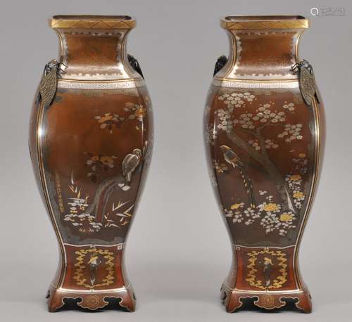 Pair of mixed metal vases. Japan. Meiji period. (1868-1912). Square form with rounded corners. Foliate feet. Pair of acadas at the shoulders. Inlays of gold, silver and various alloys. Decoration of birds and flowering trees. Signed. 12-1/2
